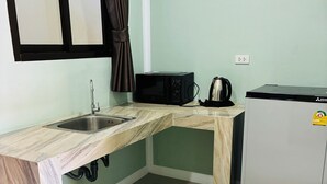 A compact kitchen with a sink, a microwave, a kettle, and a refrigerator. - Rainbow Room No.13 Front of Haad Rin (Koh Samui)