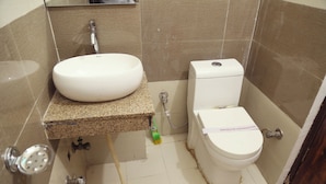 Casa de banho com lavatório branco, sanita e chuveiro.