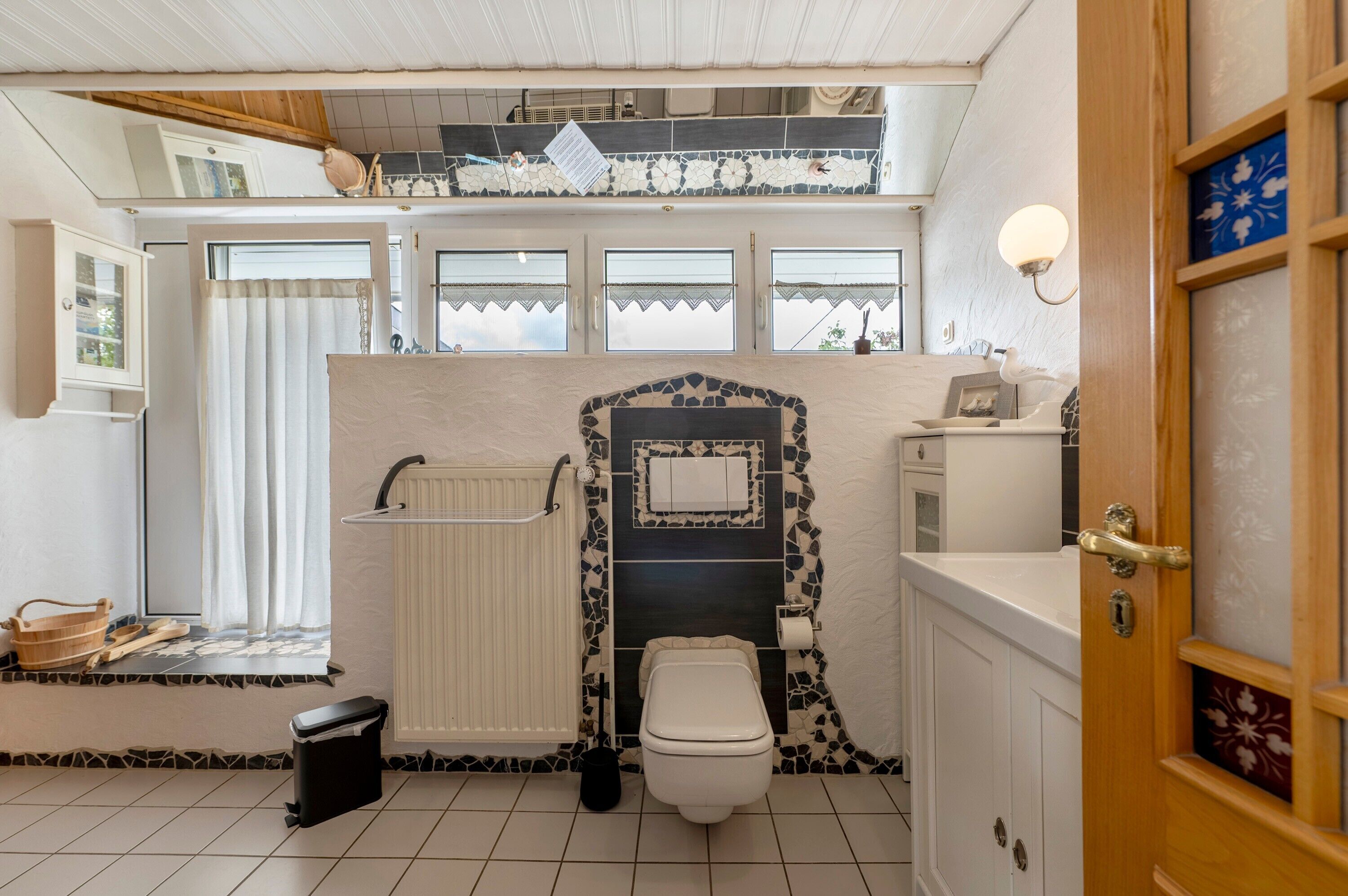 Ein Badezimmer mit Toilette, Waschbecken, Dusche und Fenster.