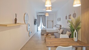 A modern hotel room with a wooden dining table, a sofa, and a TV. - SILIA Reno Studio Athens Ambelokipi Metro (Athens)