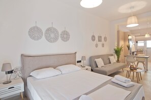 Une chambre d’hôtel moderne dotée d’un grand lit, d’un canapé, d’un bureau et d’un coin repas.