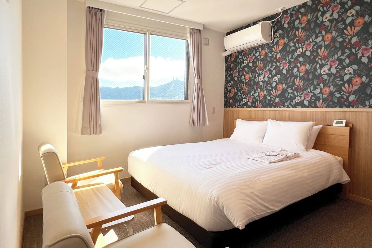 Una habitación de hotel con cama, escritorio y silla.