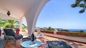 A terrace with a table, chairs, and a bottle of wine. - El Retiro by Interhome (Calpe/Calp)