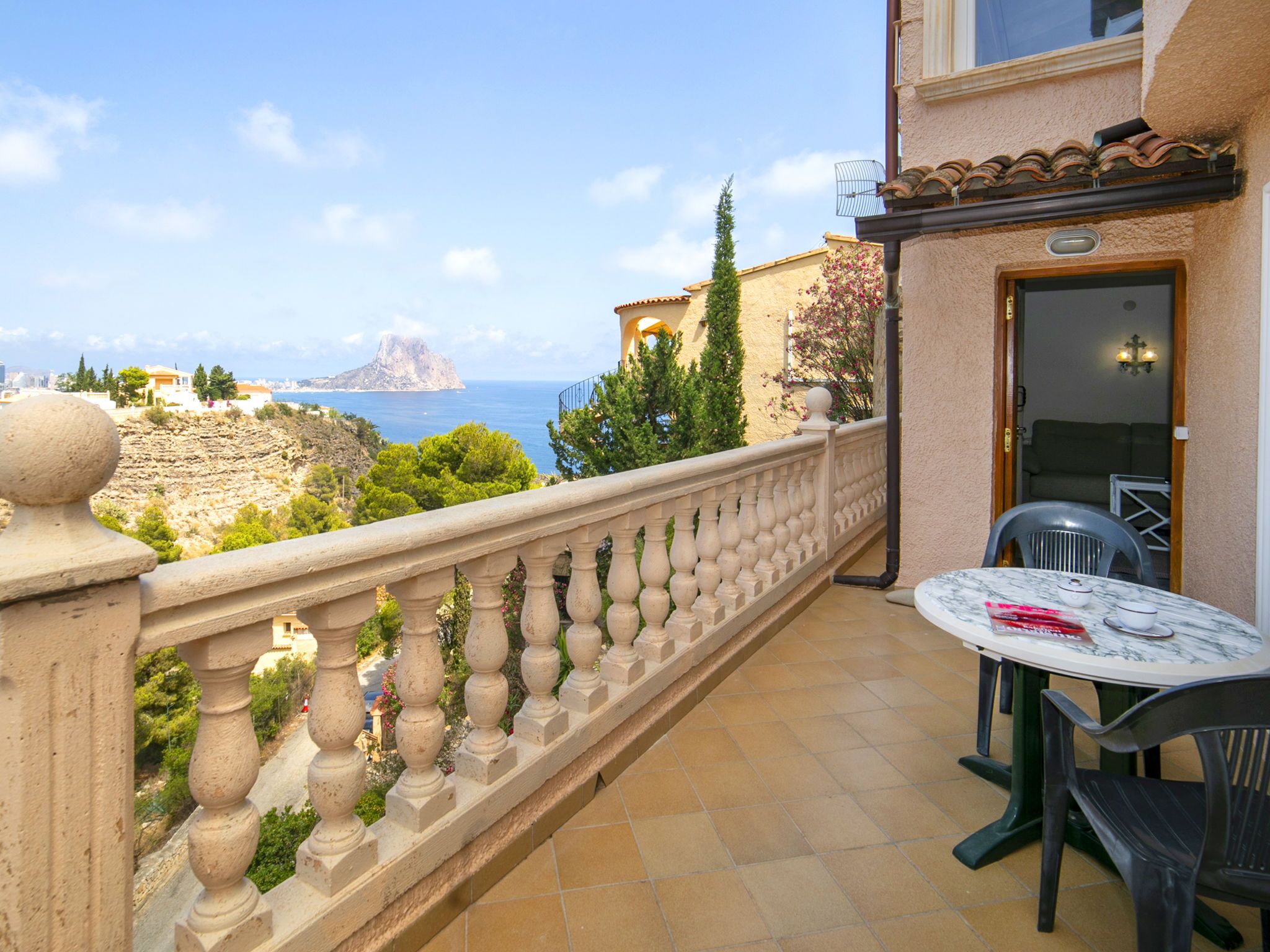 A balcony with a view of the sea and a mountain.