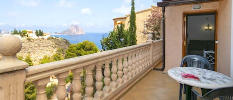 A balcony with a view of the sea and a mountain.