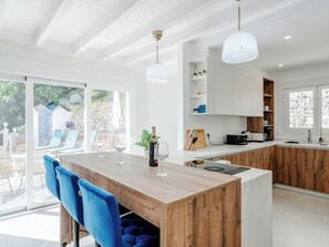 A modern kitchen with a wooden island, white cabinets, and pendant lighting. - Brisa del Mar by Interhome (Calpe/Calp)
