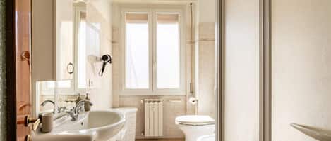 Regadera, secadora de cabello, bidet, toallas