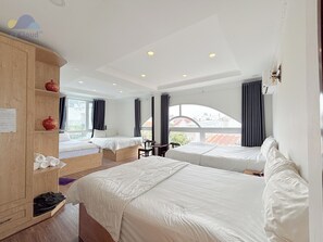 Habitación de hotel con dos camas, un armario de madera, un escritorio y vistas a la ciudad.