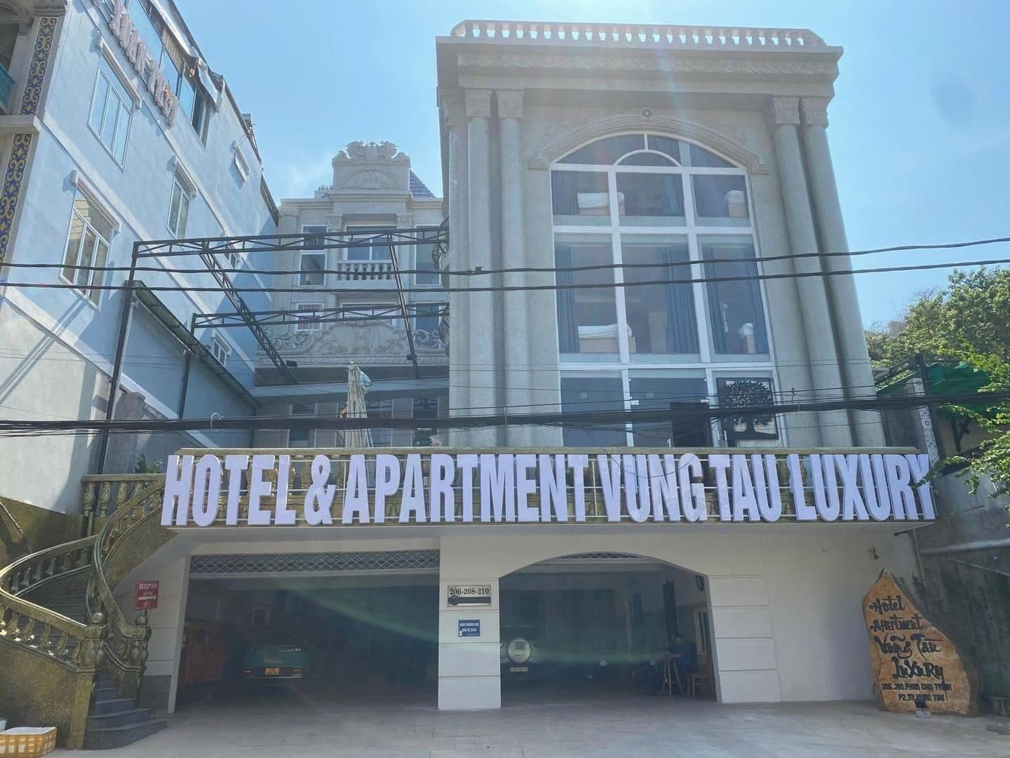 Ein Gebäude mit einem Schild, auf dem „HOTEL & APARTMENT VUNG TAU LUXURY“ steht.