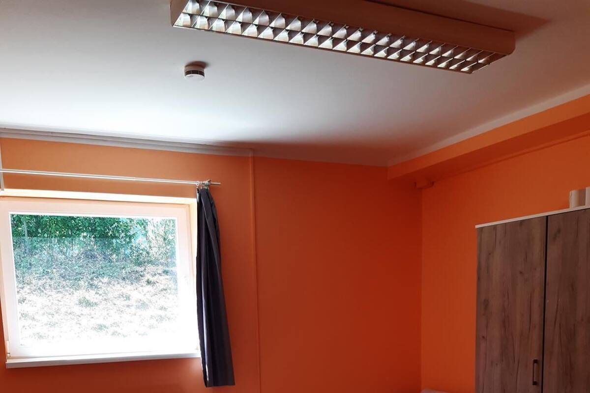 Een kamer met een bed, een tafel en een kledingkast.