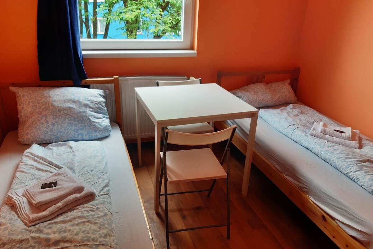 Une petite pièce agréable, dotée d’un lit simple, d’un bureau et d’une chaise.