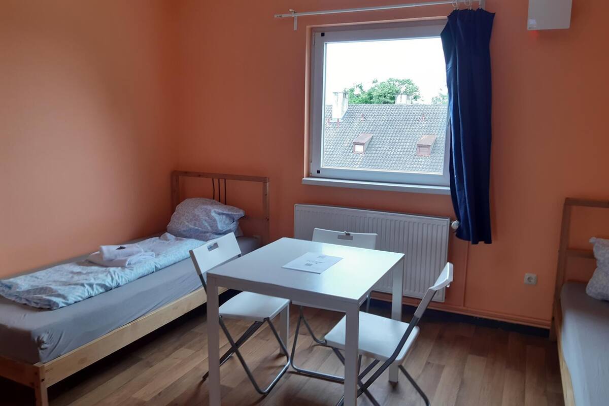 Un alojamiento pequeño y de una sola habitación, con cama, mesa y silla.