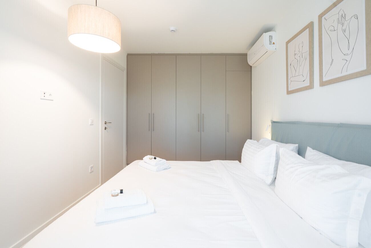 A hotel room with a bed, a wardrobe, and a ceiling light.