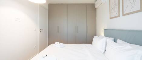 A hotel room with a bed, a wardrobe, and a ceiling light.