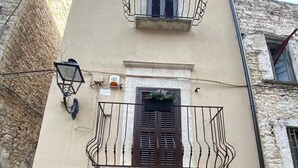 Un bâtiment doté d’un balcon, d’une porte et d’une fenêtre.