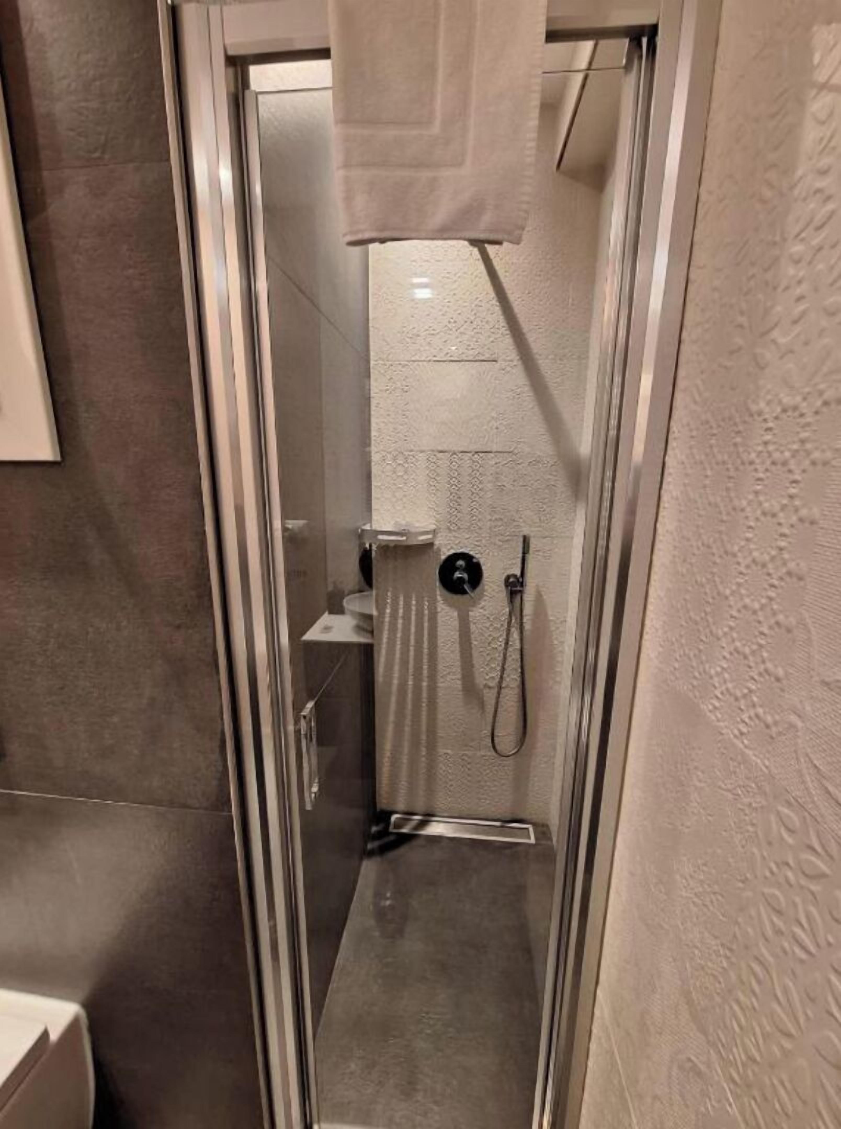 Un baño moderno con ducha acristalada, inodoro y lavamanos.