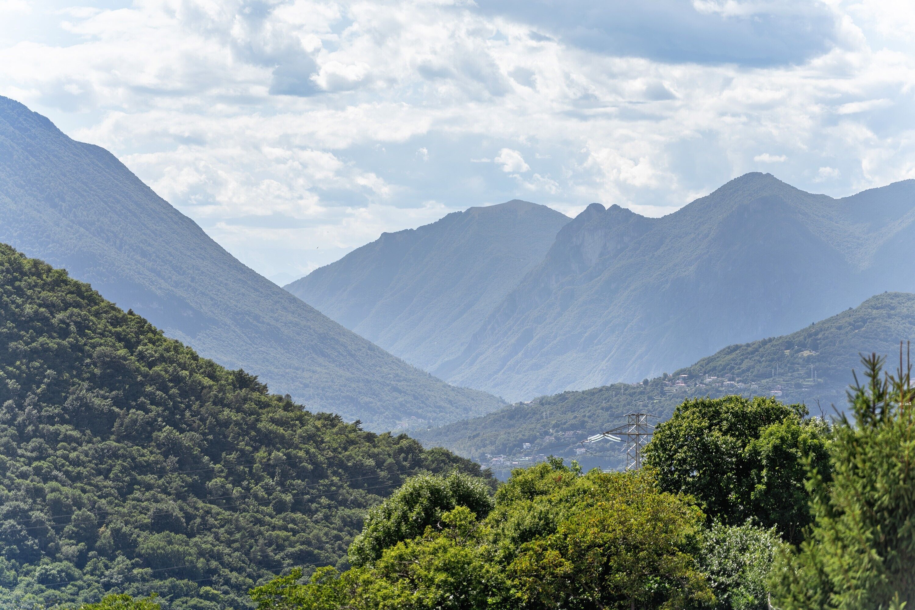 Un paysage montagneux, avec de vastes forêts verdoyantes et une vallée.
