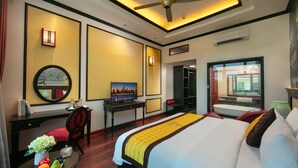 Una camera d'albergo con un letto, una scrivania, una sedia e vista sulla città.