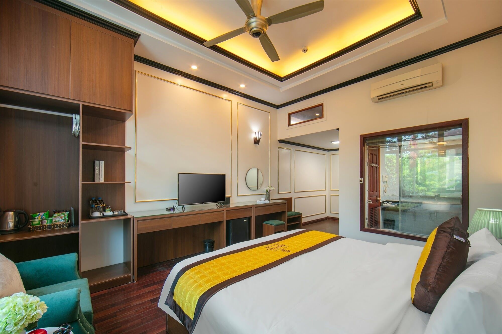 A hotel room with a bed, desk, and wardrobe.
