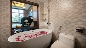 Un bagno moderno con una vasca freestanding, una doccia e un water.
