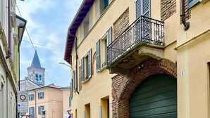 Una estrecha calle adoquinada bordeada por edificios históricos, con una imponente torre de iglesia al fondo.