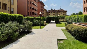 A pathway leading to a building with multiple floors, surrounded by well-maintained hedges and greenery. - Cielo C18 by Houset - Two Bedroom Apartment, Sleeps 5 (Cinisello Balsamo)