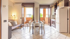 A modern kitchen with a dining area, white appliances, and a view to the outside. - Cielo C18 by Houset - Two Bedroom Apartment, Sleeps 5 (Cinisello Balsamo)