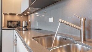 A modern kitchen with stainless steel appliances, a double sink, and a sleek countertop design.