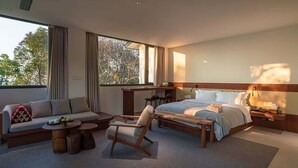 Una habitación de hotel moderna con cama, sofá, escritorio y silla.