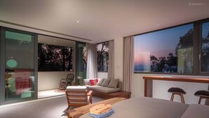 Una habitación de hotel moderna con una cama grande, un escritorio y un área de descanso con vistas a los cerezos en flor.
