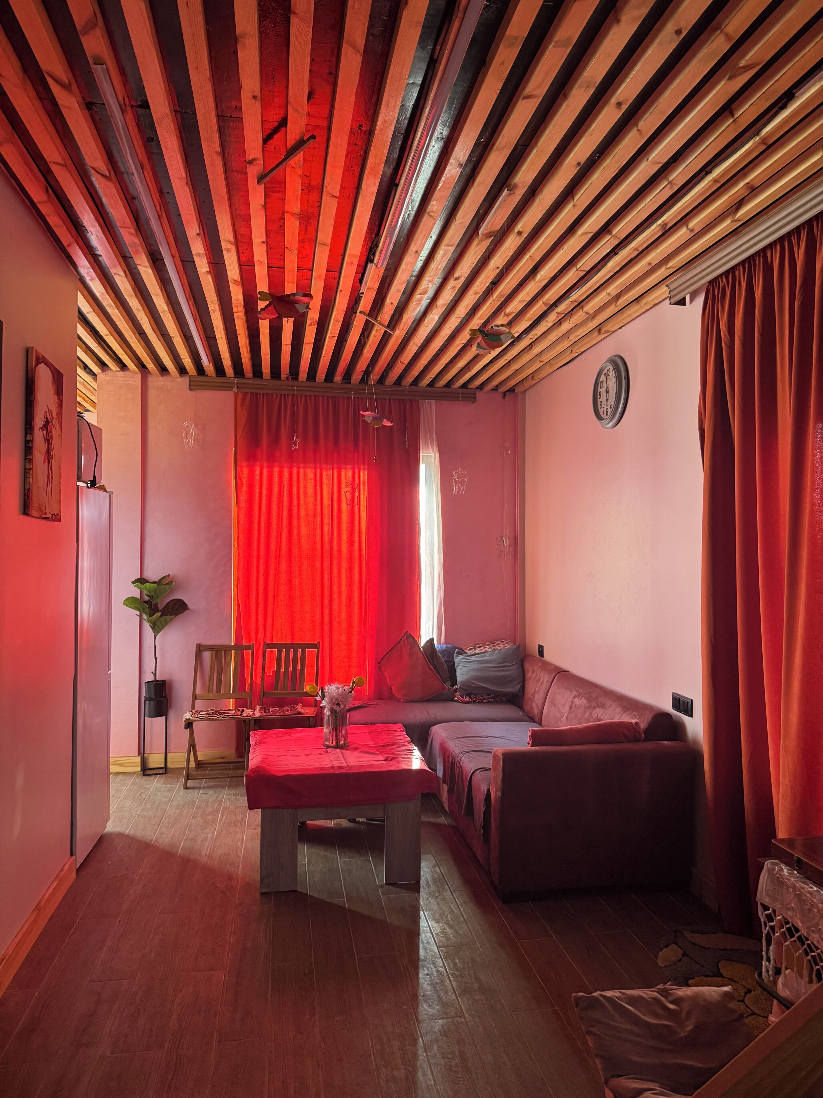 Una stanza con soffitto spiovente, un divano, un tavolo e una sedia.
