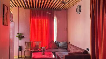 Una stanza con soffitto spiovente, un divano, un tavolo e una sedia.