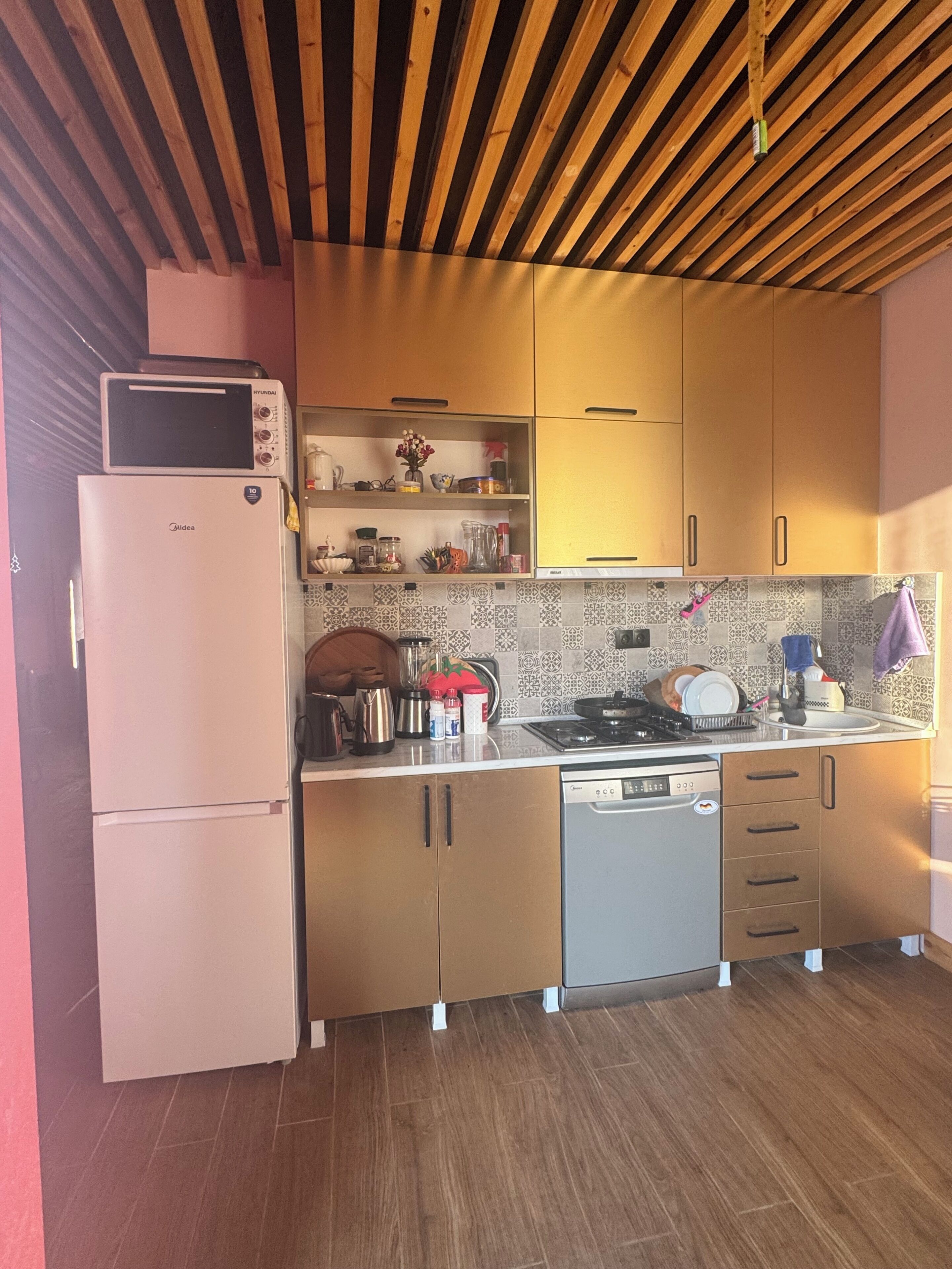 Una cocina compacta equipada con microondas, refrigerador, estufa y lavavajillas.
