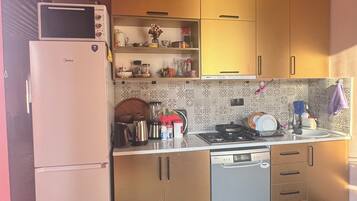 Una cocina compacta equipada con microondas, refrigerador, estufa y lavavajillas.