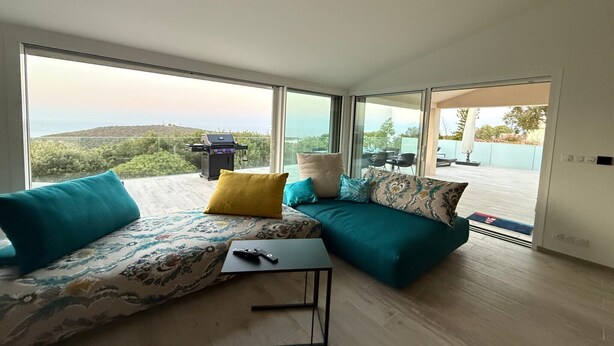 A modern living room with a sofa set, a small table, and a remote control on it. - Vacation home near Porto Vecchio (Porto-Vecchio)