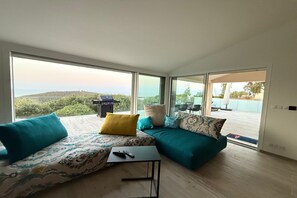 Un salon moderne avec un ensemble de canapés, une petite table et une télécommande posée dessus.