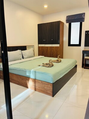 A bedroom with a bed, wooden headboard, a wardrobe, and a window with blinds. - Hillside Haven-Luxury Room (Koh Samui)