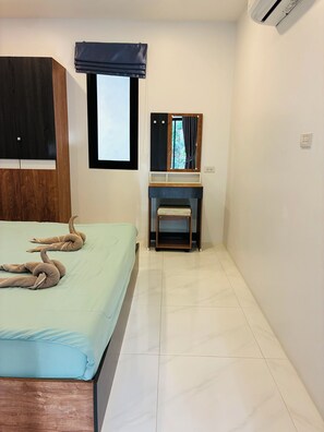 Une chambre à coucher avec un lit, une armoire en bois, une petite table, un miroir et une fenêtre donnant sur un paysage agréable.