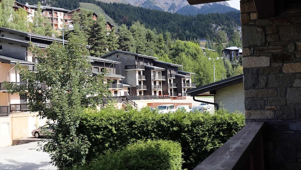 A multi-story building with balconies, surrounded by greenery and mountains in the background. - Spacious apartment for 6 people with WIFI in Aussois (Aussois)