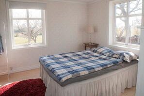 Une chambre à coucher avec un lit, une fenêtre et une table de chevet.