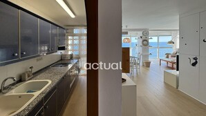 A modern kitchen with granite countertops, stainless steel appliances, and a view to the living area.