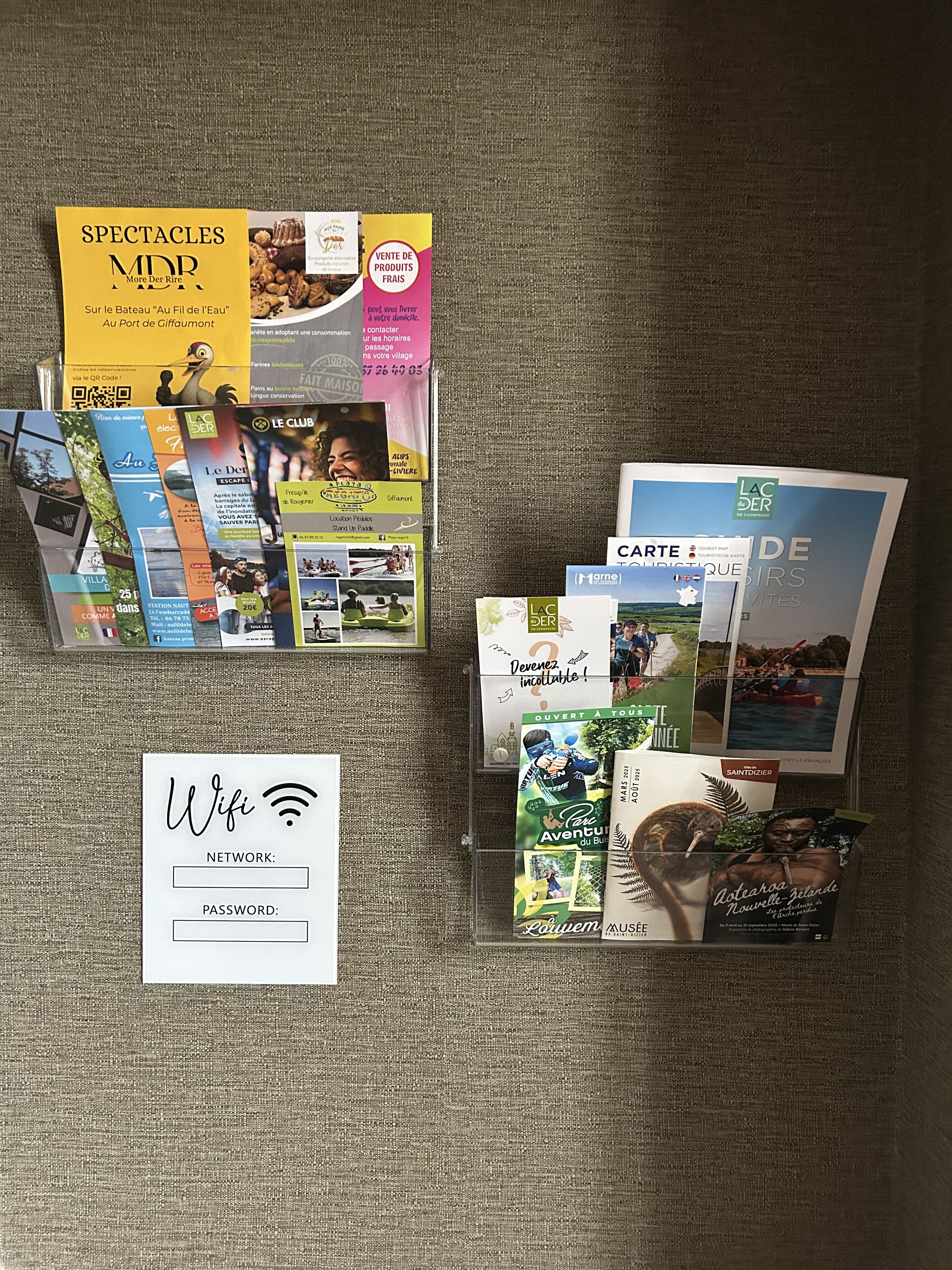 Une collection de brochures et un panneau Wi-Fi sur une surface texturée.