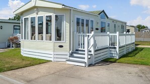 A single-story mobile home with a porch and a small set of stairs leading to the entrance. - 2 bedroom accommodation in Patrington Haven (Patrington Haven)