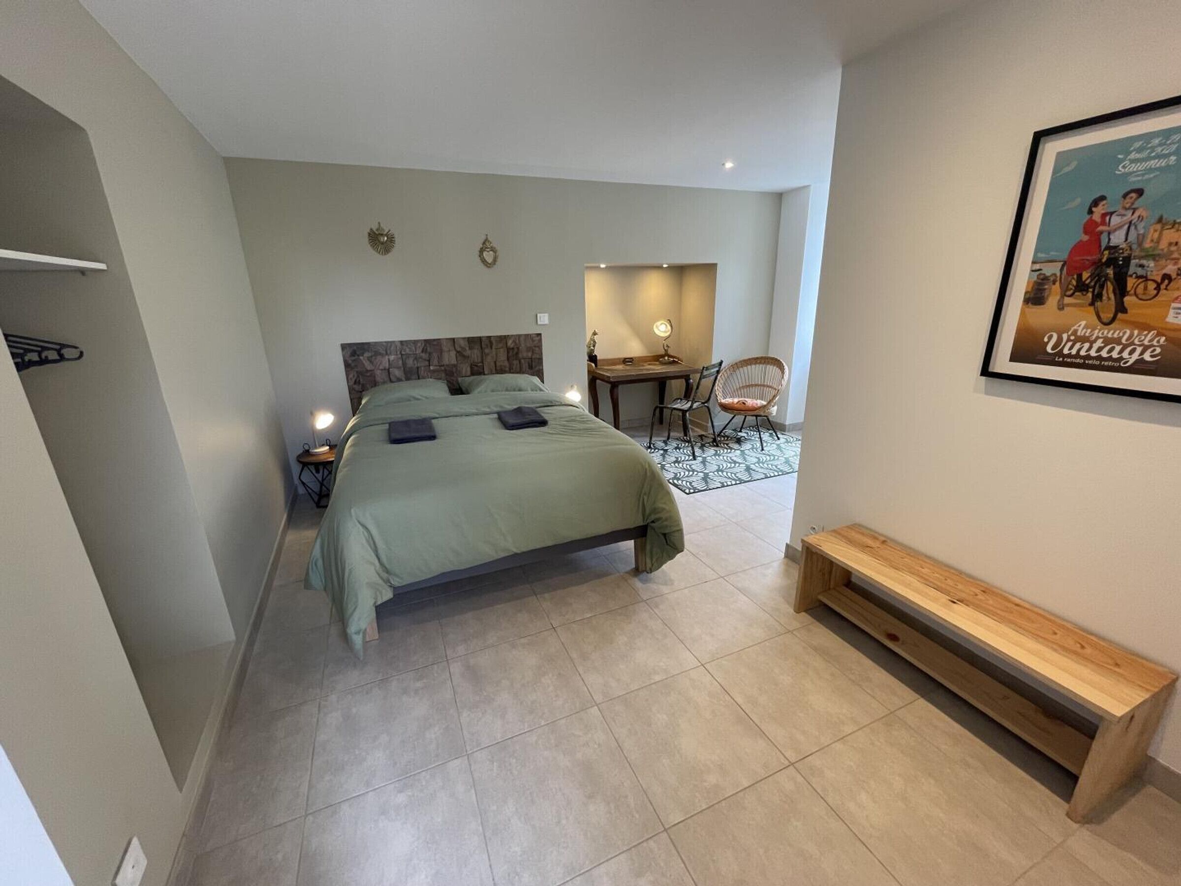 A modern bedroom with a bed, bedside tables, a desk, and a chair.