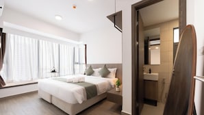 Un hotel moderno con una cama grande, una mesita de noche pequeña, una planta en maceta y vistas de la ciudad a través de la ventana.