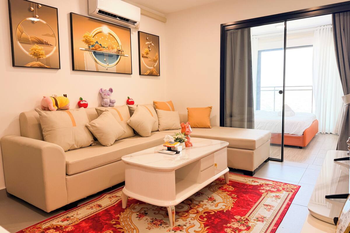 Una sala de estar moderna con un sofá, una mesa de centro y un ventanal con cortinas.