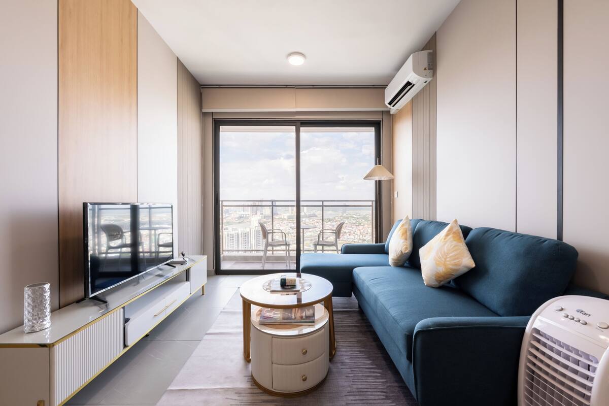 Una sala de estar moderna con televisor, sofá y una pequeña mesa.