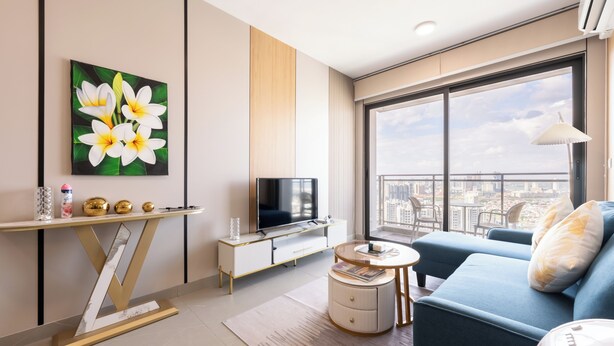 Una sala de estar moderna con un sofá, televisor y obras de arte en la pared.