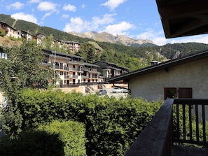 Ein Bergresort mit mehrstöckigen Gebäuden, Balkonen und Blick auf die umliegenden Berge.