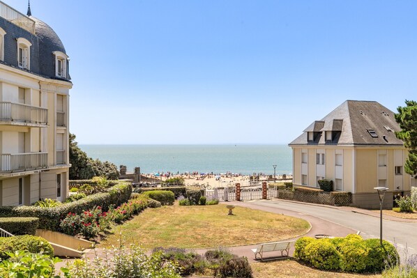 Un hôtel situé sur la côte, offrant une vue sur la mer, doté d’un jardin et d’une route menant à la plage.
